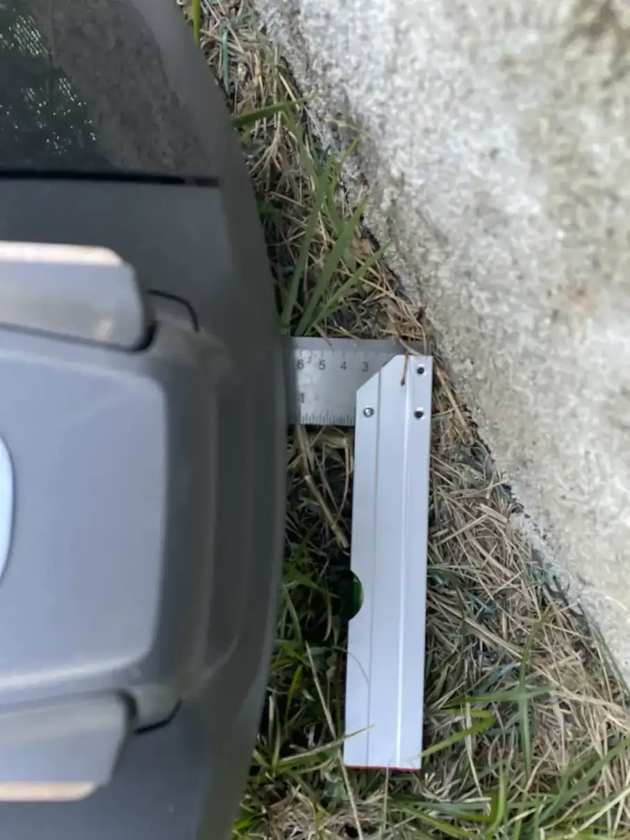 Règle entre la carrosserie du Husqvarna R6V et un mur vertical