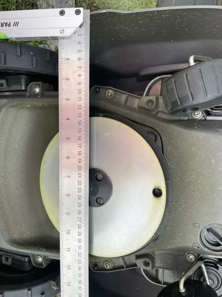 Règle placée sous le Husqvarna R6V entre la coque et la plaque métallique circulaire visible