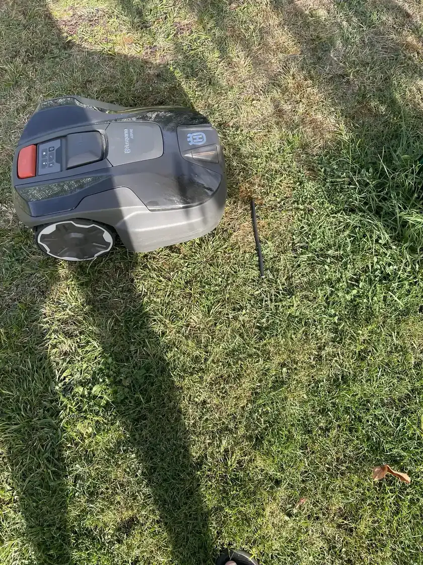 Husqvarna R6V pendant un essai avec un câble noir fin posé dans l’herbe